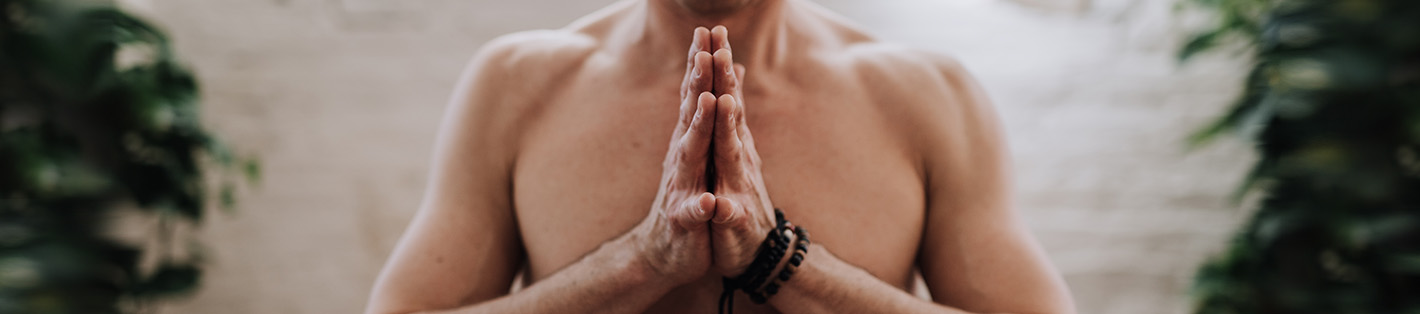 Man with hands together on chest while performing yoga